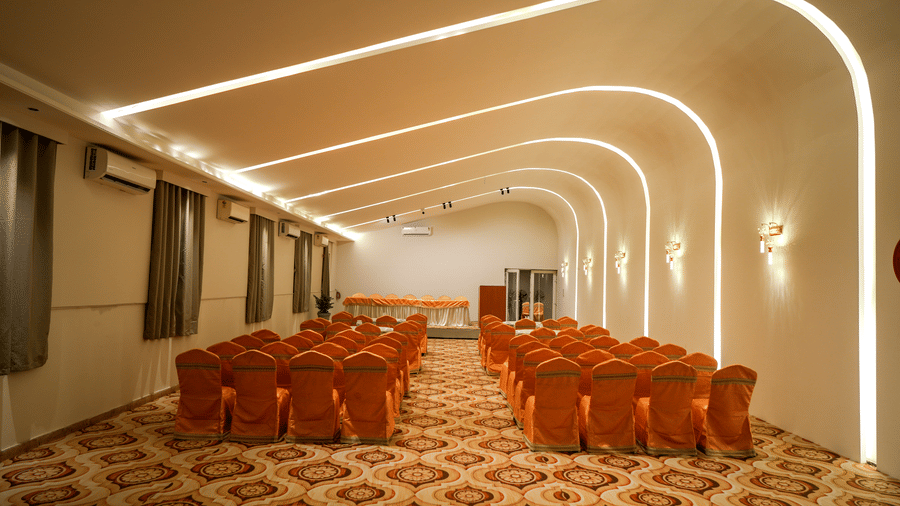 Conference hall with chairs arranged in rows at Pravasa Hotel, Kolhapur.
