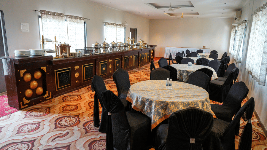 Dining area with tables and buffet counter at Pravasa Hotel, Kolhapur.