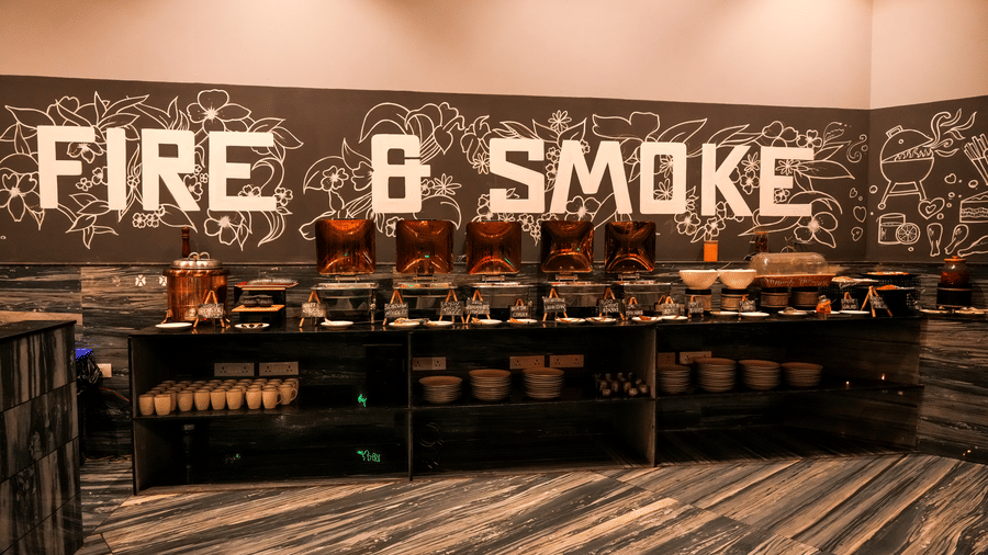 Restaurant buffet counter with “Fire & Smoke” sign at Pravasa Hotel, Kolhapur.