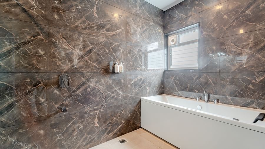 Modern bathroom with a bathtub, and contemporary fixtures | Studio Suite | Pravasa Hotel, Vijayapura