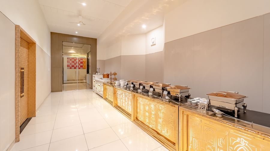 A buffet setup with serving dishes and elegant golden accents | Meetings & Events | Pravasa Hotel, Vijayapura