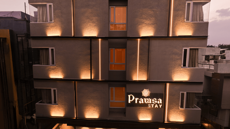 The glowing entrance and facade of Pravasa Stay Bapat Square, Indore during the evening.