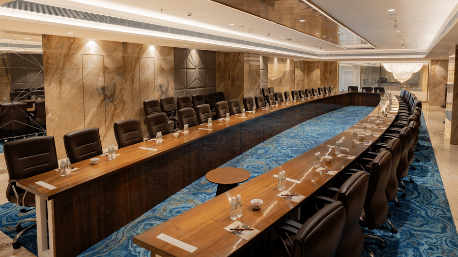 An angled view of a professional conference hall featuring ergonomic black chairs and high-end lighting.