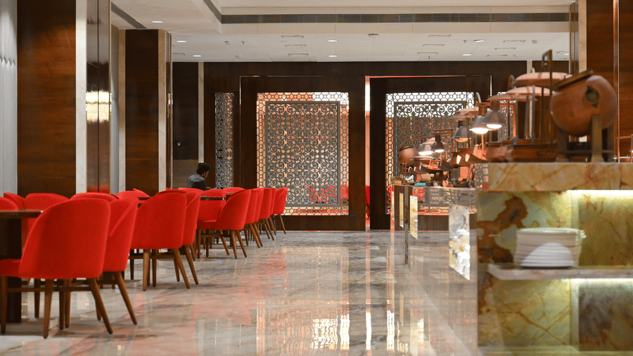 The elegant dining area at Lambic banquet hall in Praveg's Grand Eulogia, Ahmedabad, featuring comfortable seating, polished interiors, and a spacious layout for gatherings.
