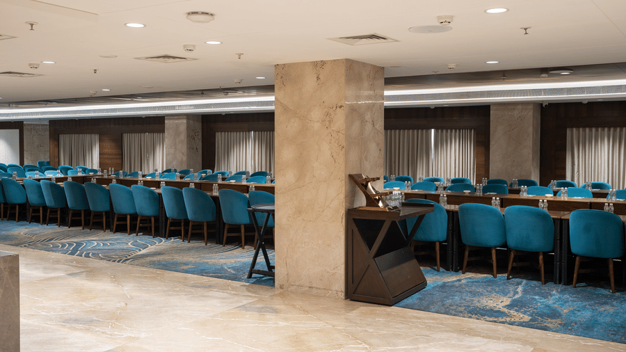 Interior of a spacious event hall showing marble pillars and extensive seating for corporate functions - Praveg's Grand Eulogia, Ahmedabad
