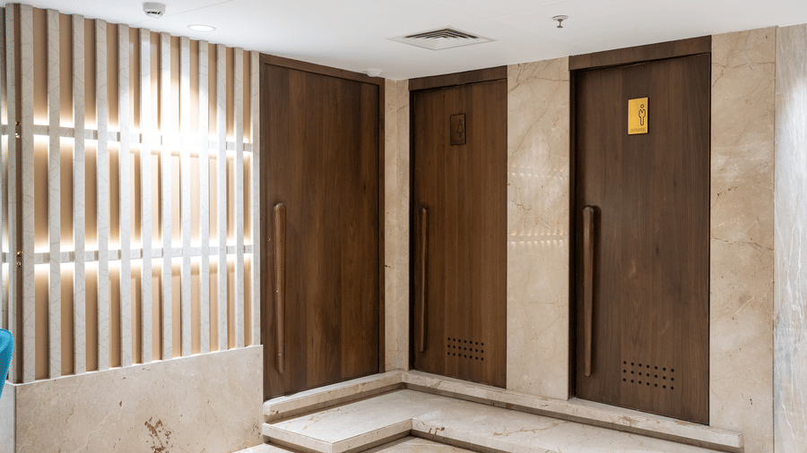 Elegant wooden double doors leading into a luxury event space with decorative wall panelling - Praveg's Grand Eulogia, Ahmedabad