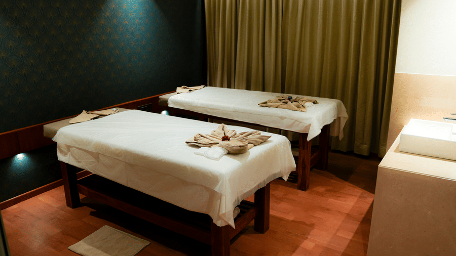 A serene spa treatment room featuring two professional massage beds with elegant linens - Praveg's Grand Eulogia, Ahmedabad