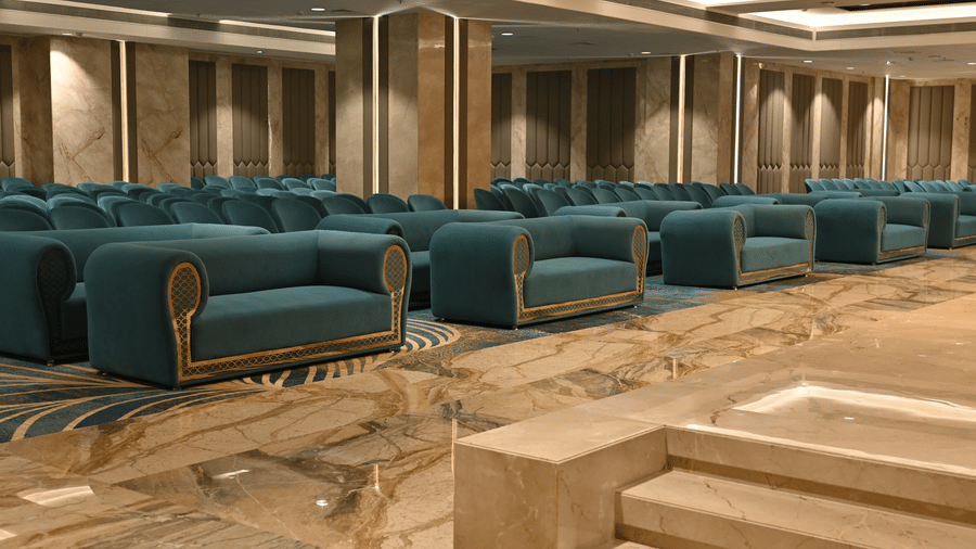 Plush seating couches are arranged in neat rows across a polished marble floor in the Marquis banquet hall at Praveg's Grand Eulogia, Ahmedabad.