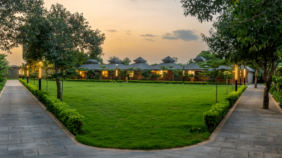Sunset view of the lush green lawn and villas at Pushkara Resort & Spa, Ajmer