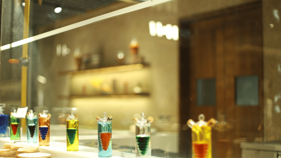 A vibrant display of colourful liquid art or cocktail ingredients behind glass at a bar in Pushkara Resort & Spa.