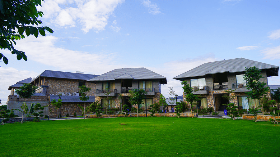 A close-up view of the resort's villas from the lawn, with the hills in the background.