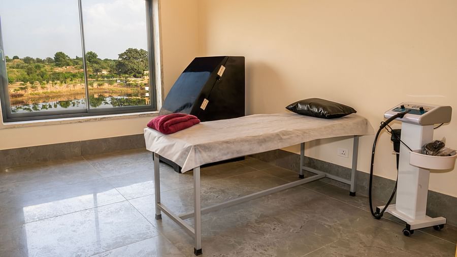 An image of a bed with blanket and pillow and next to it there are some machines - Rajbagh Wellness