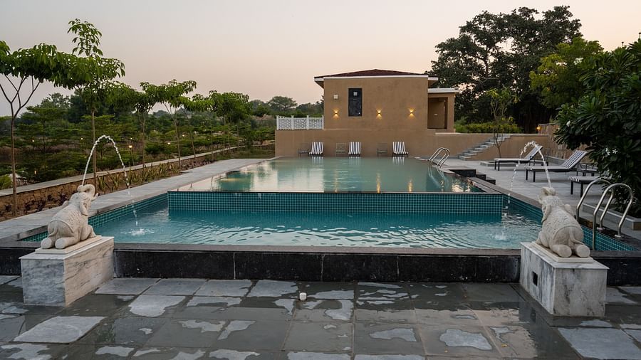 A close-up of our stunning swimming pool featuring two elegant elephant-shaped fountains gracefully pouring water into the pool - Rajbagh Wellness, Udaipur