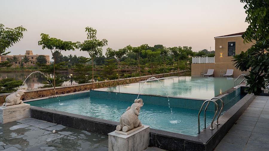 Another angle of our swimming pool showcasing the iconic elephant-shaped fountains creating a serene water display - Rajbagh Wellness, Udaipur