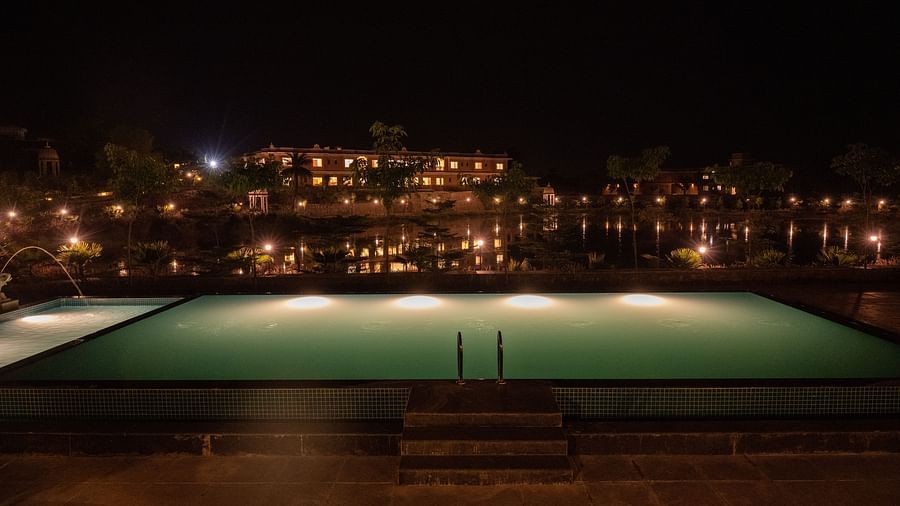 A close-up of the pool ladder bathed in soft light, capturing the serene beauty of nighttime - Rajbagh Wellness, Udaipur