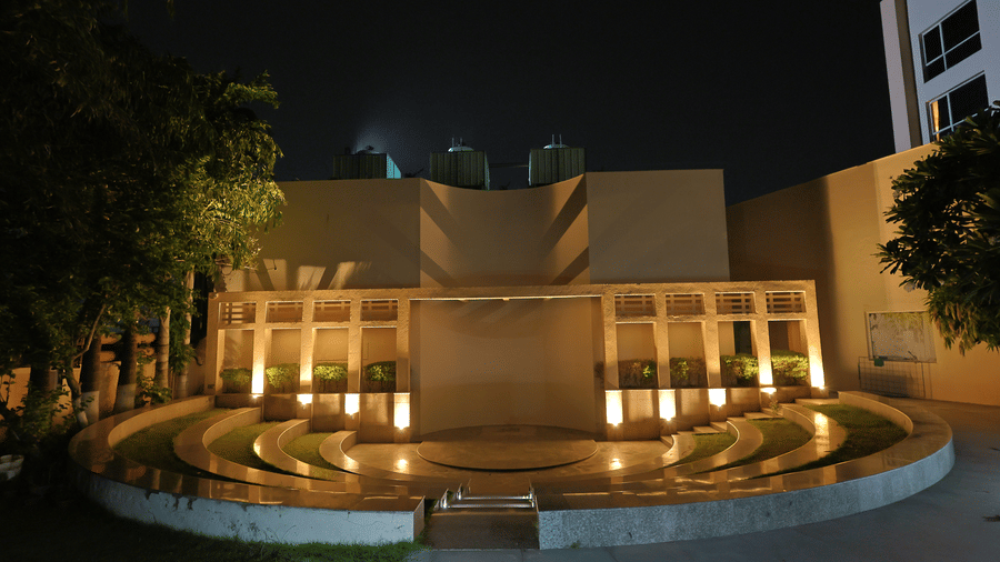 A dramatic night-time exterior shot highlights and a decorative water feature at Ramada by Wyndham Bodh Gaya Mahabodhi.