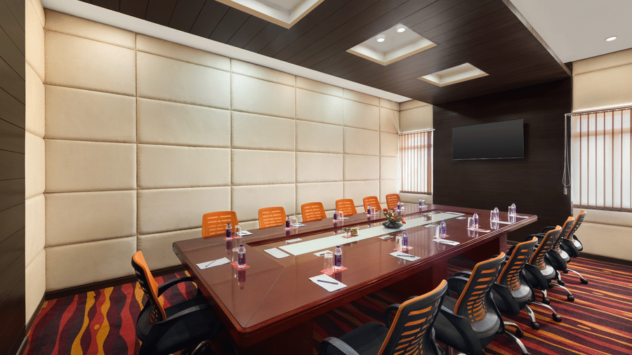 A long conference table surrounded by executive chairs fills the formal boardroom meeting space Samvaad at Ramada by Wyndham Bodh Gaya Mahabodhi.