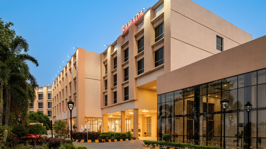 The exterior facade of Ramada by Wyndham Bodh Gaya Mahabodhi features modern architecture and landscaped surroundings for visitors.