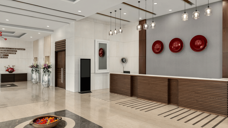 The spacious front desk area welcomes visitors with a long counter and decor in the lobby at Ramada by Wyndham Bodh Gaya Mahabodhi.