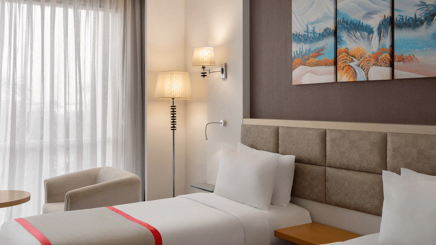 Standard Twin Room at Ramada by Wyndham Bodh Gaya Mahabodhi featuring cosy twin beds and soft ambient lighting.