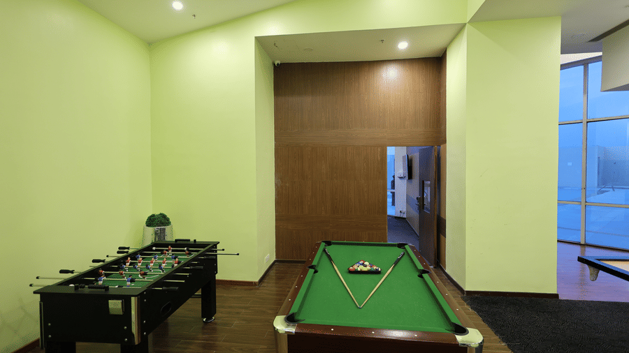 A games room with bright green walls contains a pool table and a foosball table at Ramada by Wyndham Bodh Gaya Mahabodhi.