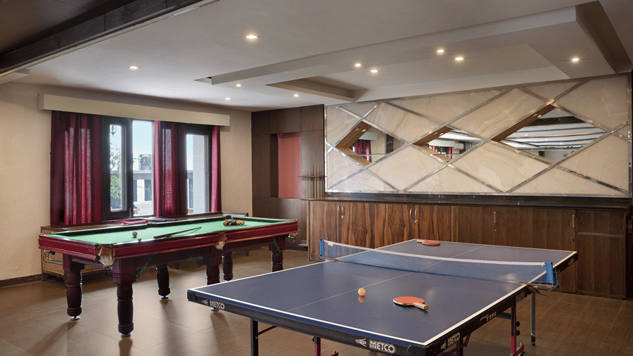 A game room containing a pool table and a table tennis table set up inside Ramada by Wyndham Mussoorie Mall Road.