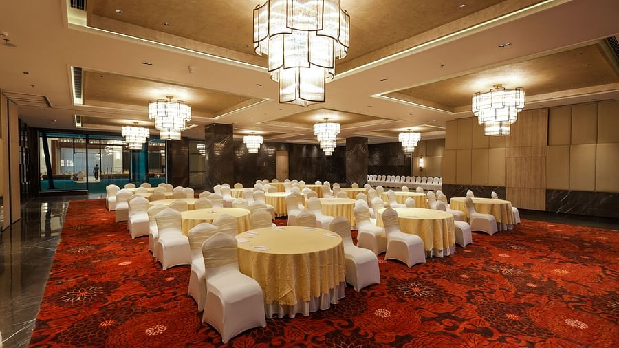 Well-lit banquet hall ready for an event with grand chandeliers at Ramada by Wyndham Sonipat Murthal