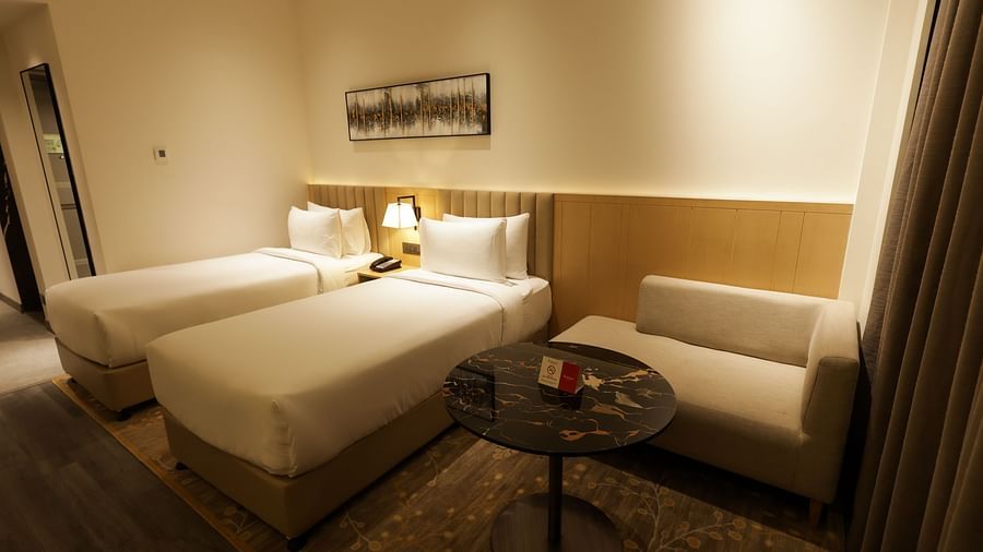 Spacious bedroom with warm lighting and seating area at Ramada by Wyndham Sonipat Murthal
