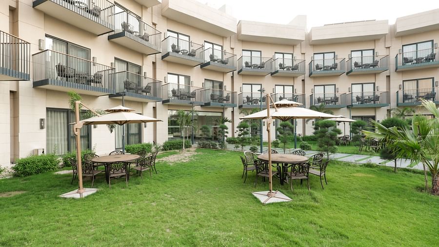 Green garden area with cabana-style seating at Ramada by Wyndham Sonipat Murthal