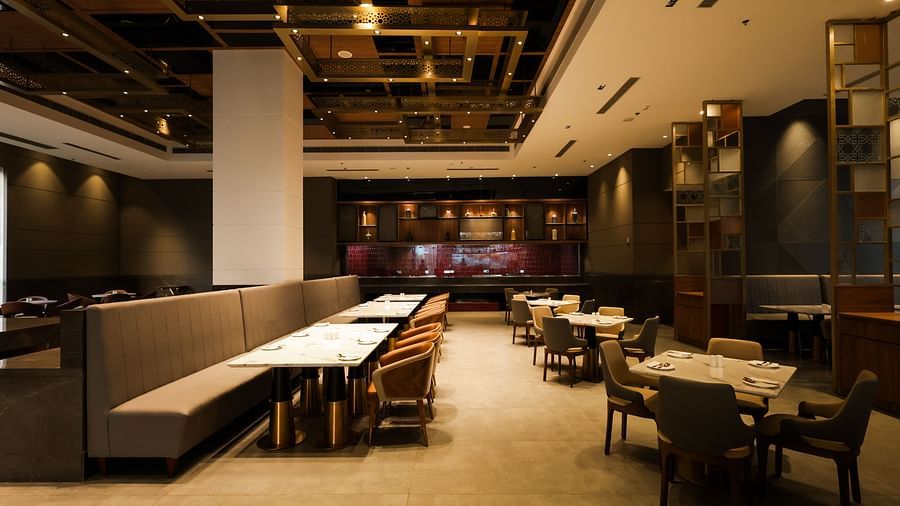 Spacious restaurant with wooden interiors and multiple dining tables at Ramada by Wyndham Sonipat Murthal