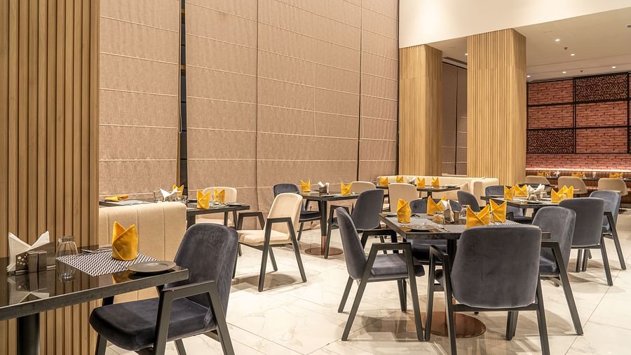 Dining setting with cutlery on a table at Ramada Encore, Bhiwadi.