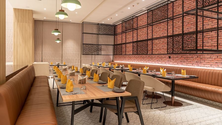Dining setting with cutlery on a table at Ramada Encore, Bhiwadi.