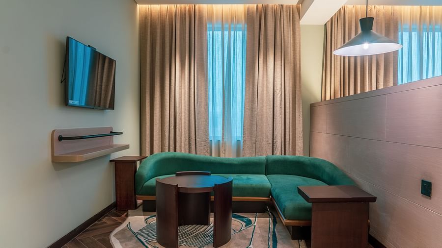 A living room area with sofa of a Junior Suite at Ramada Encore, Bhiwadi.