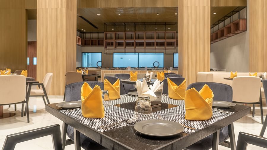 Dining setting with cutlery on a table at Ramada Encore, Bhiwadi.