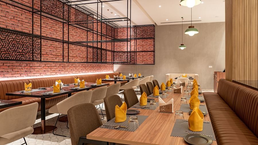 Dining setting with cutlery on a table at Ramada Encore, Bhiwadi.