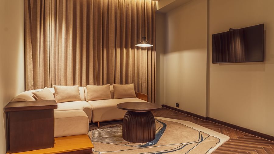 A living room area with sofa of a Suite at Ramada Encore, Bhiwadi.