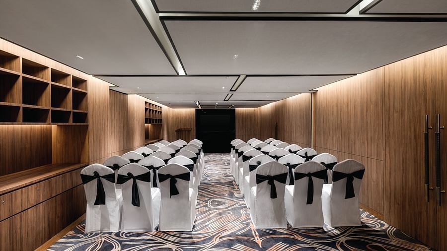 Ramada Encore by Wyndham, Bhiwadi | Event space with black chairs and stage