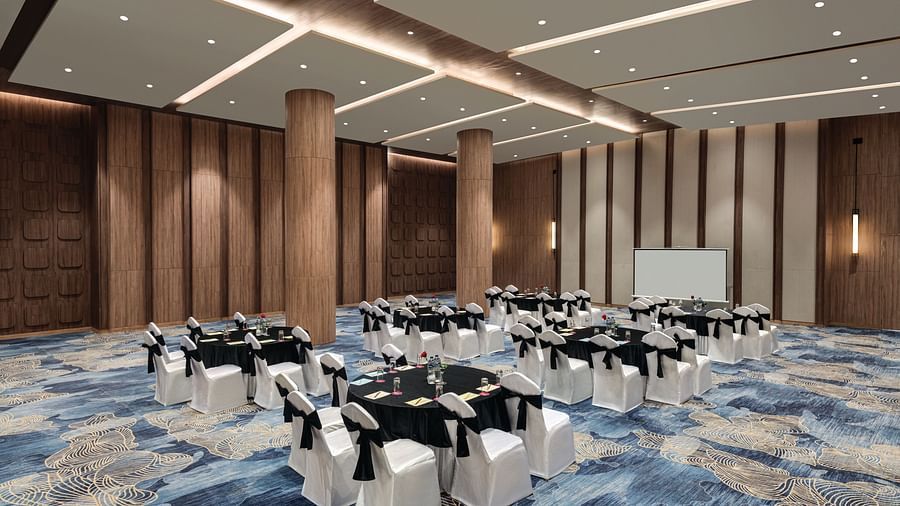 Ramada Encore by Wyndham, Bhiwadi | Large event space for formal dinner. Round tables with white tablecloths, black chairs.
