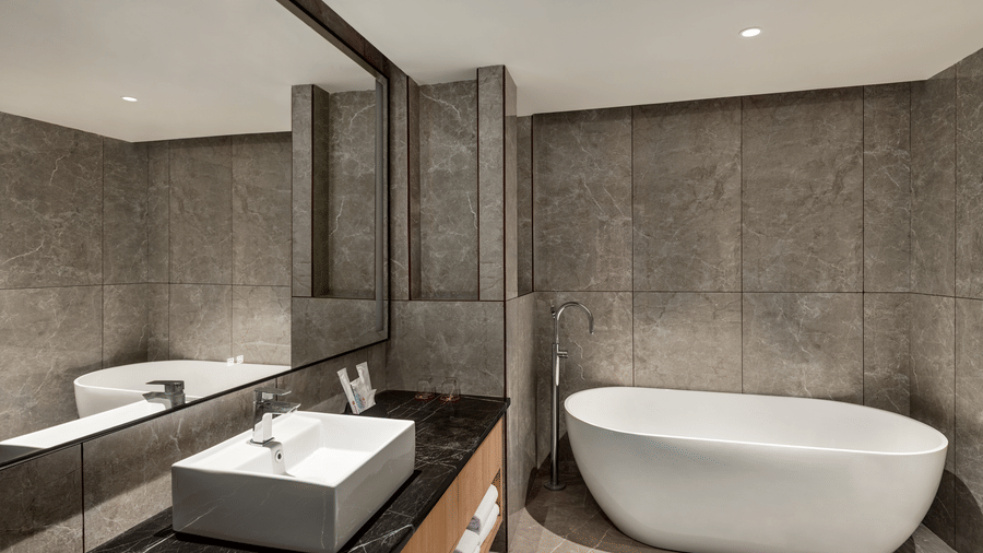 Elegant bathroom with a freestanding bathtub at Ramada Encore by Wyndham Gurugram Dwarka Expressway, featuring contemporary fixtures and interiors.