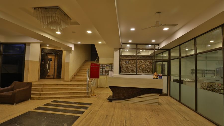 A hotel lobby area showcasing a reception desk, comfortable seating, and stairs leading upwards - Retreat Heritage, Lonavala