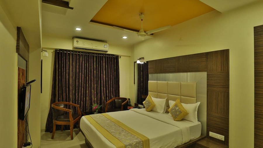 A bright hotel room with a neatly made bed, modern furniture, and warm ambient lighting - Retreat Heritage, Lonavala