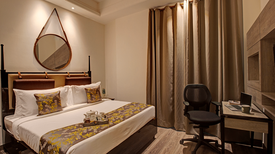 a king bed with side tables and a study desk opposite the bed inside Executive Suite at Rhythm Gurugram