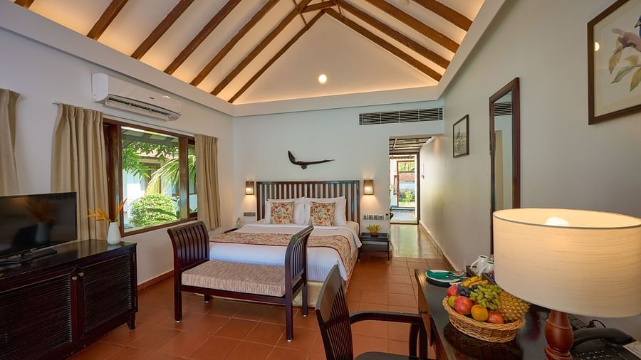 a double bed with lamps on either side inside one of the rooms - Rhythm Kumarakom