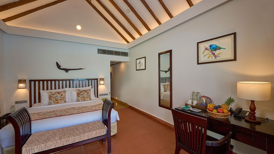 a double bed with lamps on either side inside one of the rooms - Rhythm Kumarakom