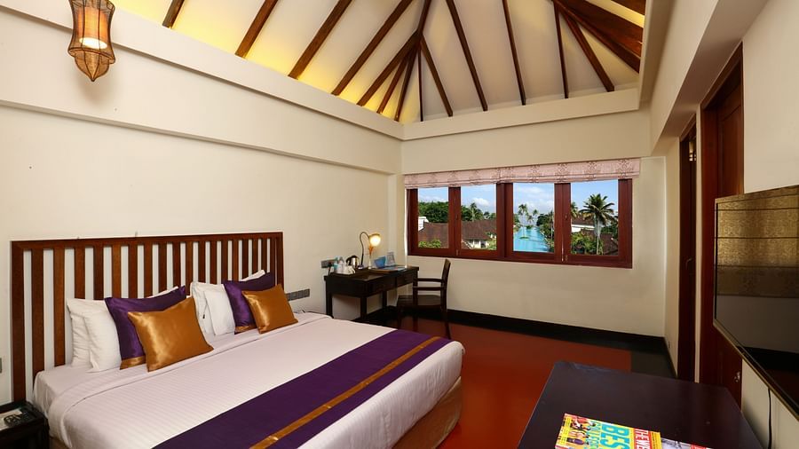 an image of a Lake View Terrace Suite Bedroom with a king bed and a light hanging from the ceiling - Rhythm Kumarakom
