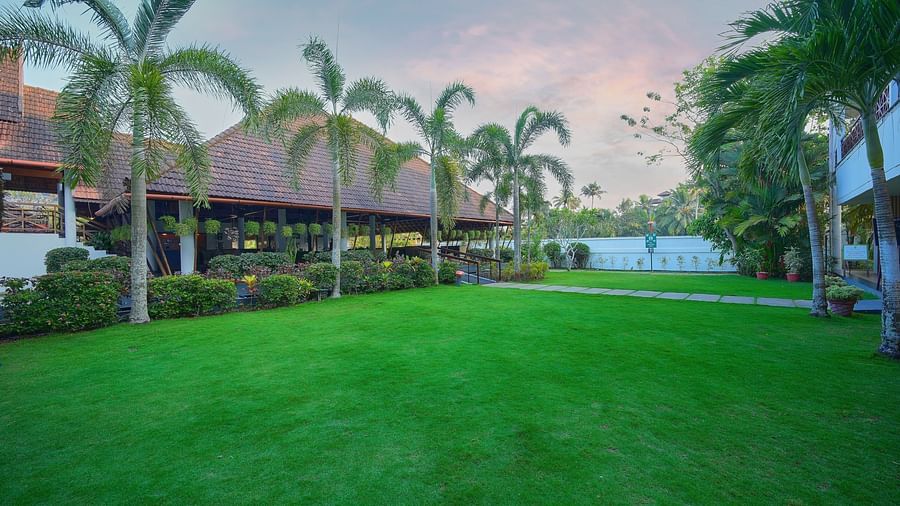 an overview of the Lawn with palm trees in front of it - Rhythm Kumarakom