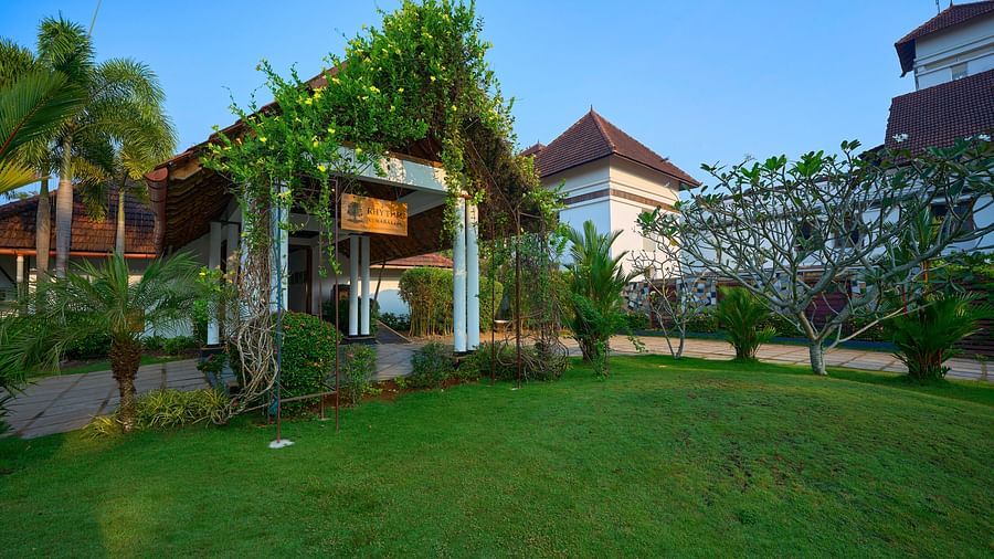 an overview of the Lawn with coconut trees in front of it - Rhythm Kumarakom