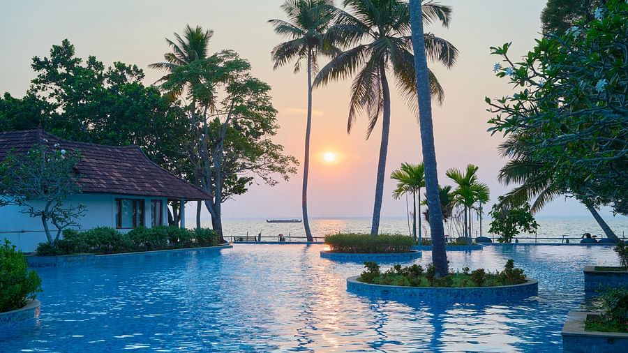 india's largest swimming pool with rooms and trees in view - Rhythm Kumarakom