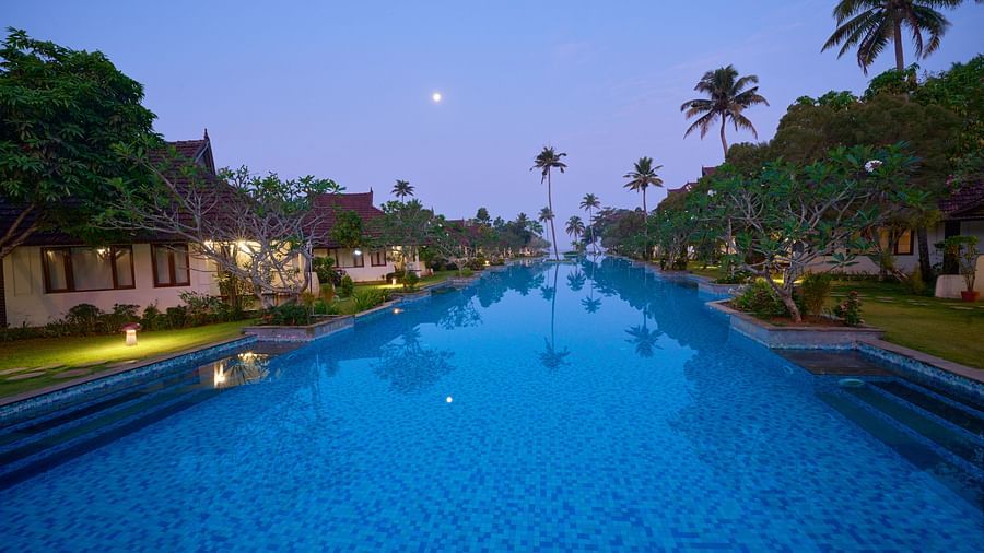 india's largest swimming pool with rooms and trees in view - Rhythm Kumarakom