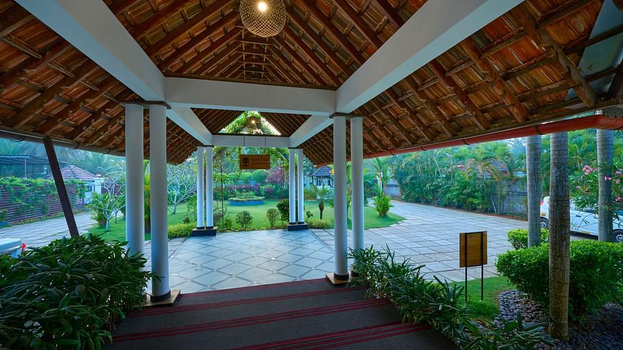 a view of the courtyard with potted plants on the side - Rhythm Kumarakom